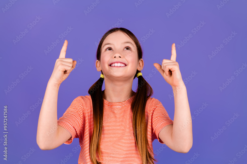 Photo portrait of pretty little girl point look up empty space wear trendy red outfit isolated on purple color background Photo portrait of pretty little girl point look up empty space wear trendy red outfit isolated on purple color background