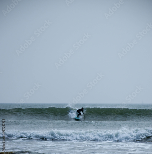 Dynamic silhouette of a surfer catching a wave during golden hour.