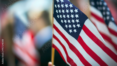 The American flag waves gently in the sunset as silhouetted people stand in reverence, symbolizing unity and reflection.