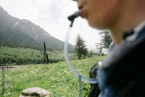 teen hydrating while on  the Tour du Mont Blanc, in the Swiss Alps,  photo