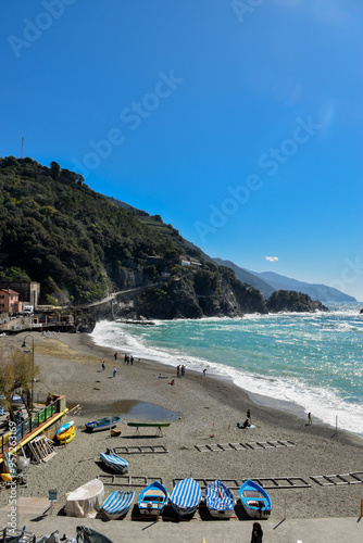 Coast and view of a summer in Italy, with colorful architecture and buildings behind crystal blue waters.
