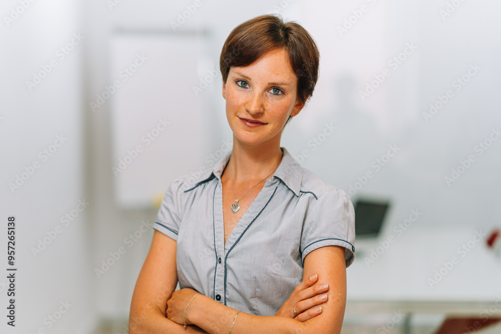 Smiling businesswoman looking at camera in workplace Smiling businesswoman looking at camera in workplace