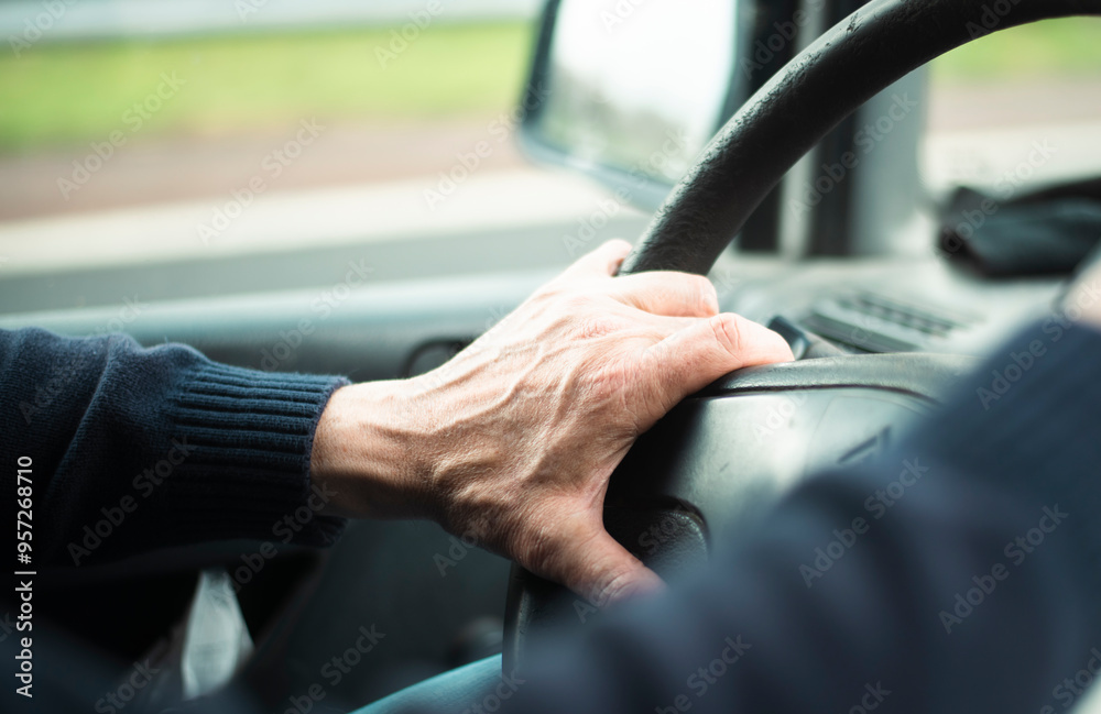 Senior driver holding steering wheel: focused hand on wheel in motion Senior driver holding steering wheel: focused hand on wheel in motion