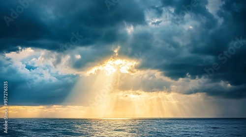 Sun rays breaking through dark storm clouds over the ocean, dramatic weather, hope after the storm