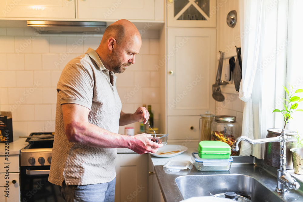 Mature Man Cleaning Utensils and Dishes After Dinner Mature Man Cleaning Utensils and Dishes After Dinner