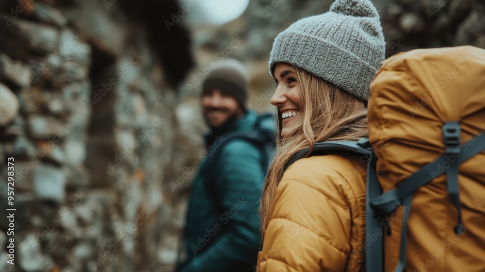 Two hikers traverse a village trail lined with rustic stone structures, wearing backpacks and warm clothing, symbolizing adventure and exploration in a serene setting. Two hikers traverse a village trail lined with rustic stone structures, wearing backpacks and warm clothing, symbolizing adventure and exploration in a serene setting.