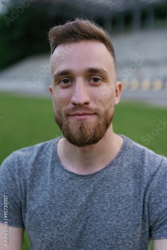 Portrait of a bearded athlete in a gray T-shirt at the stadium