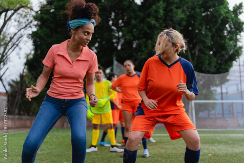 Female soccer coach guiding a football player.