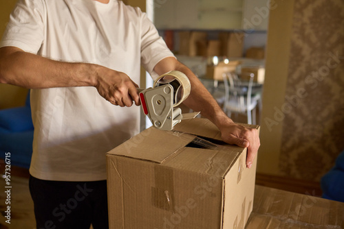 A person is packing a moving box in a cozy, inviting, and comfortable home setting photo