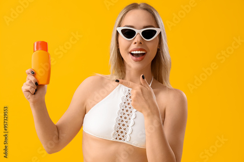 Young woman pointing at sun...