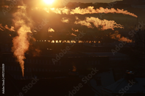 The sun is setting and the sky is filled with smoke photo