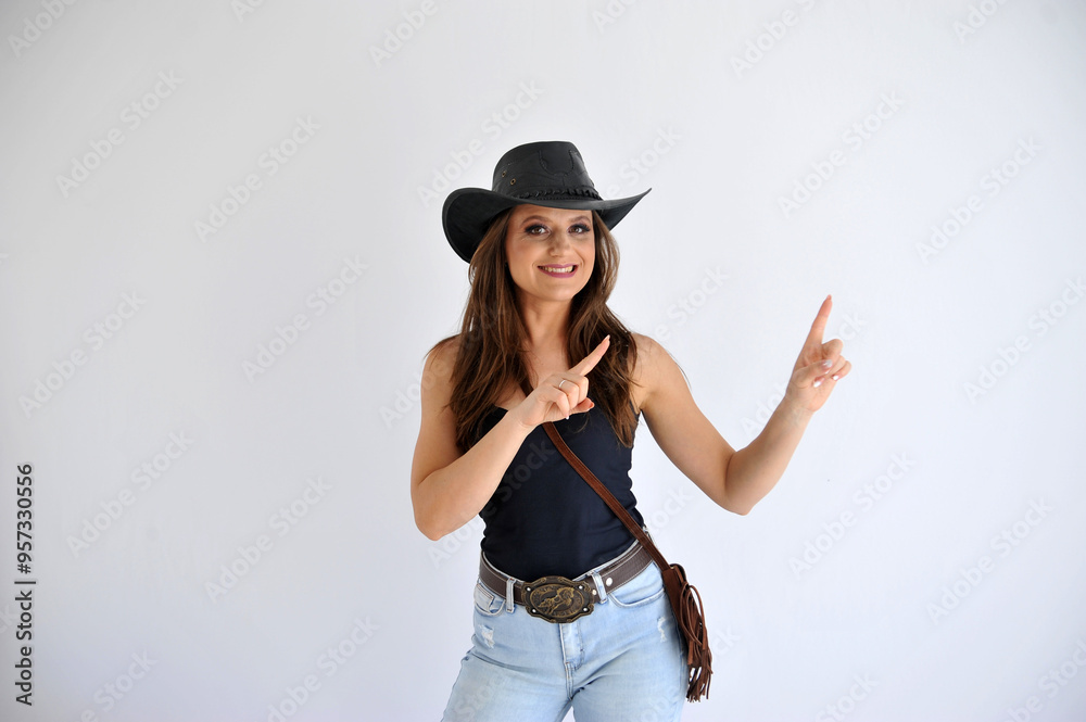 Beldade mulher vaqueira com chapéu country, expressão feliz aponta para promoção Beldade mulher vaqueira com chapéu country, expressão feliz aponta para promoção