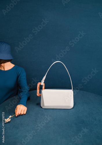 Stylish Woman Displaying Elegant Fashion Handbag On Blue Backgro