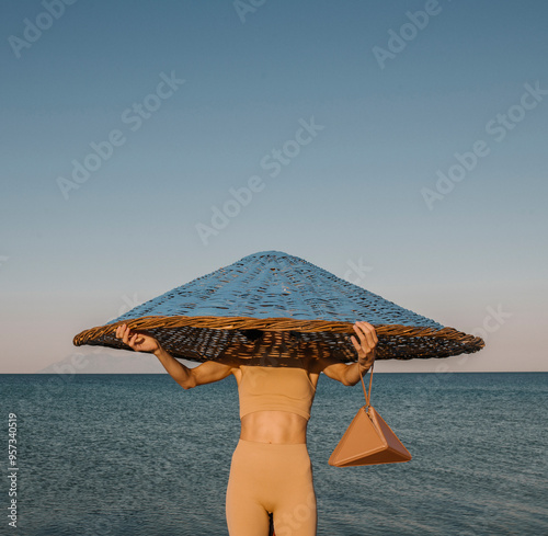 Person Holding Large Hat While Standing by the Ocean