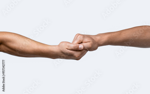 Two hands touching each other on a gray isolated background. Handshake, arms, friendship. Friendly handshake, friends greeting, teamwork friendship. Rescue, helping gesture or hands. Strong hold