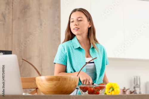 Young woman cutting cucumbe...