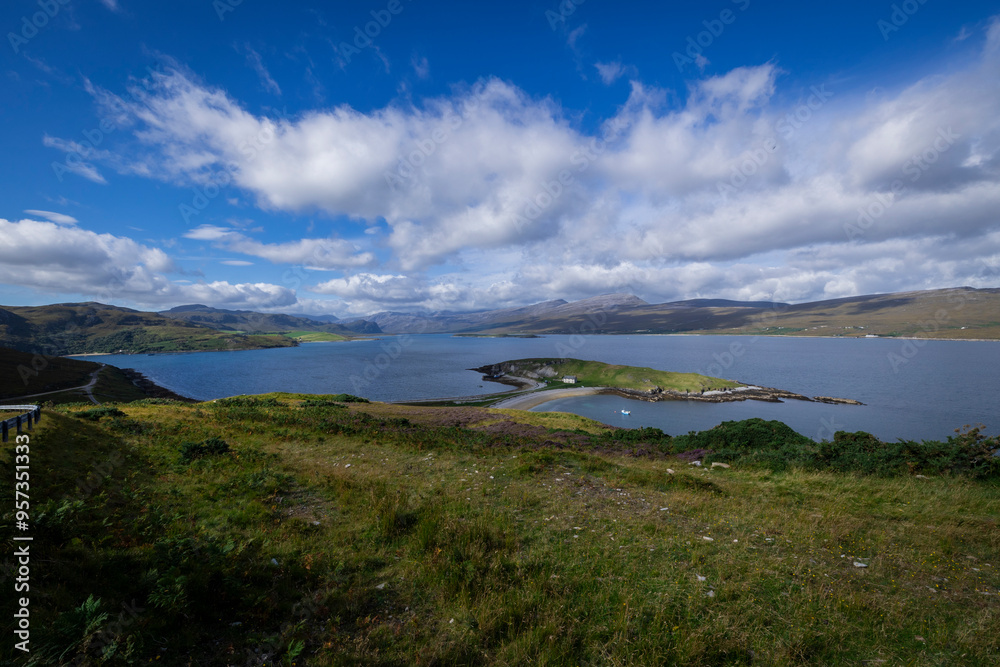 The image shows a body of water surrounded by grass and hills in a natural landscape in Scotland. It captures a serene outdoor scene with a cloudy sky. The image shows a body of water surrounded by grass and hills in a natural landscape in Scotland. It captures a serene outdoor scene with a cloudy sky.