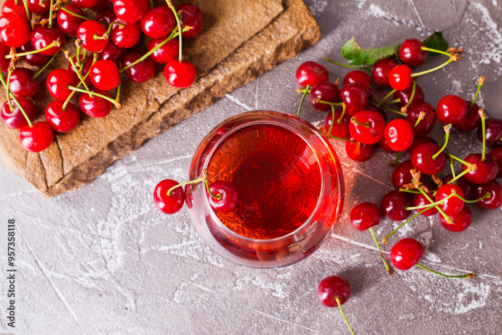 Cherry juice in a transparent glass and fresh cherries Cherry juice in a transparent glass and fresh cherries