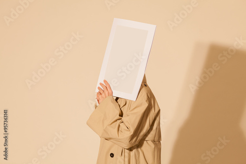 Anonymous Person Holding Blank Frame Against Beige Background photo