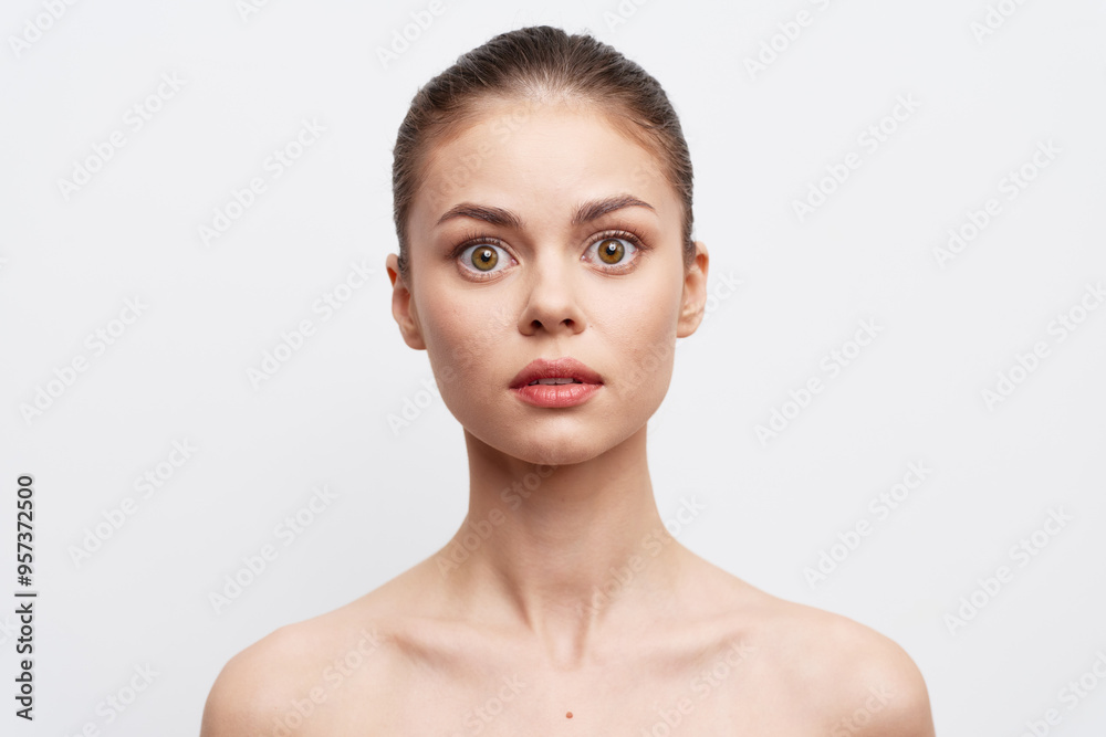 Portrait of a surprised young woman with natural makeup on a plain background, conveying emotions of astonishment and curiosity Ideal for expressive and emotional content Portrait of a surprised young woman with natural makeup on a plain background, conveying emotions of astonishment and curiosity Ideal for expressive and emotional content
