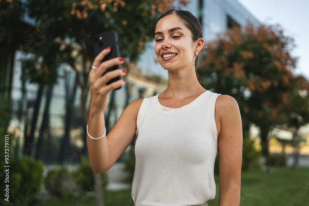 Young woman stand in front company have video call on mobile phone Young woman stand in front company have video call on mobile phone