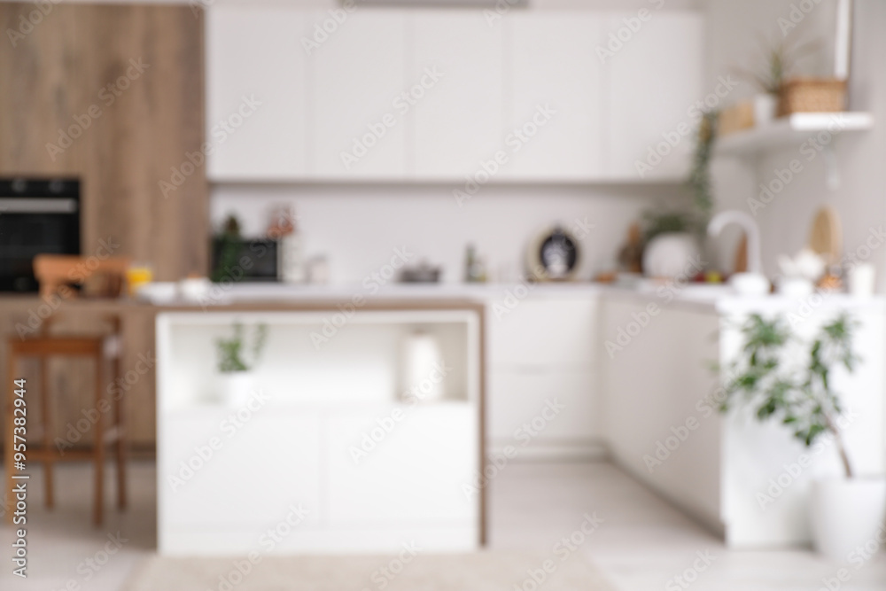 Blurred view of light kitchen with counters, table and plants Blurred view of light kitchen with counters, table and plants