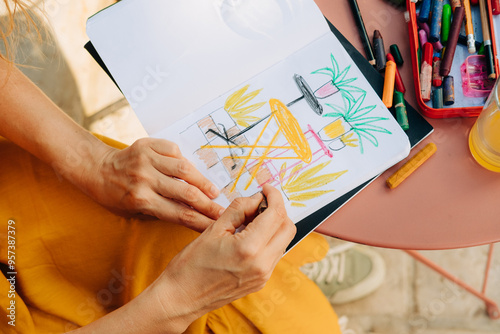 Top view of illustrator's hands making drawing in a sketchbook photo