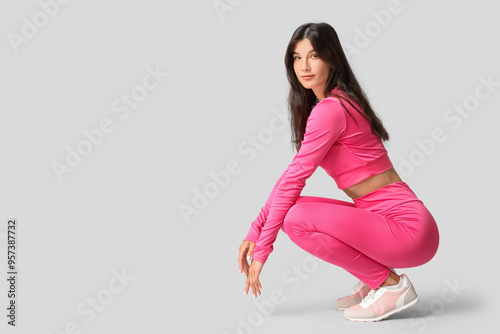 Sporty young woman on grey ...