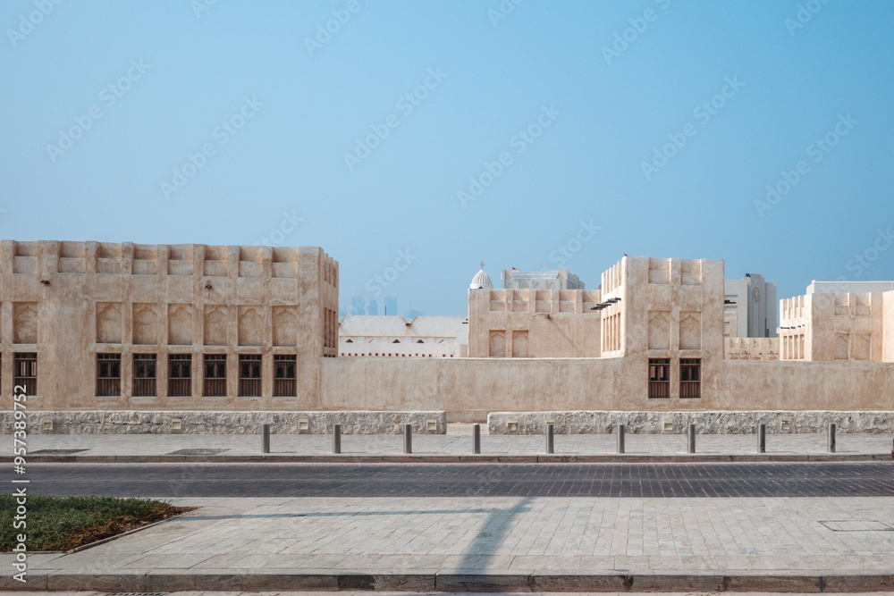 Fototapeta premium The exterior of a traditional Middle Eastern mud brick building with a row of arched windows of Domes Mosque in Doha, Qatar.