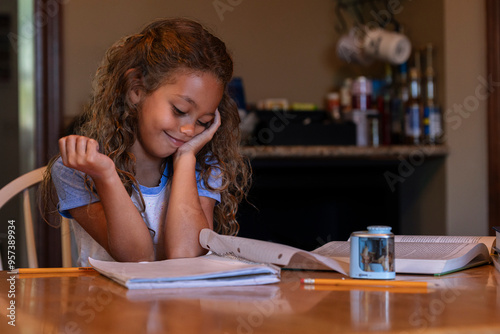 Girl doing homework at kitchen table photo