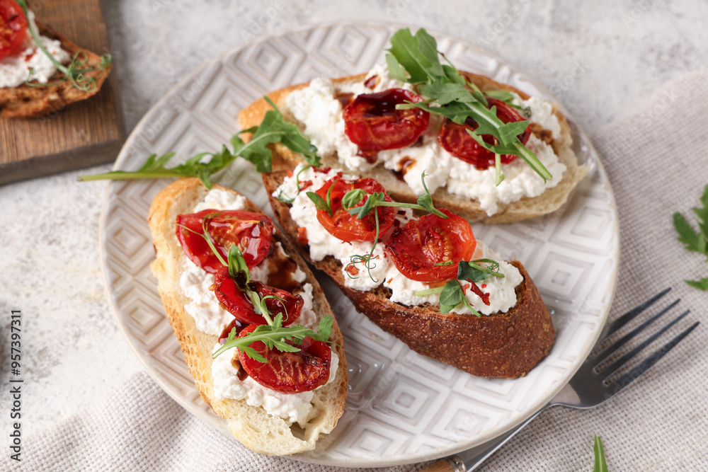 Plate of tasty tomato bruschetta with ricotta and arugula on white background Plate of tasty tomato bruschetta with ricotta and arugula on white background