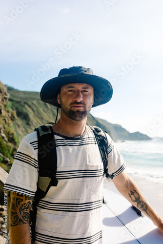 Tourist posing with his surf gear from a cliff at Campello beach photo