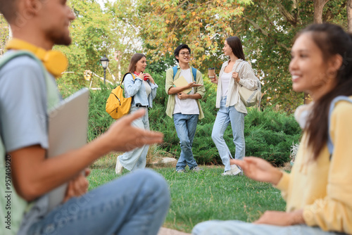 Diverse group of university students talking and walking on campus, education...
