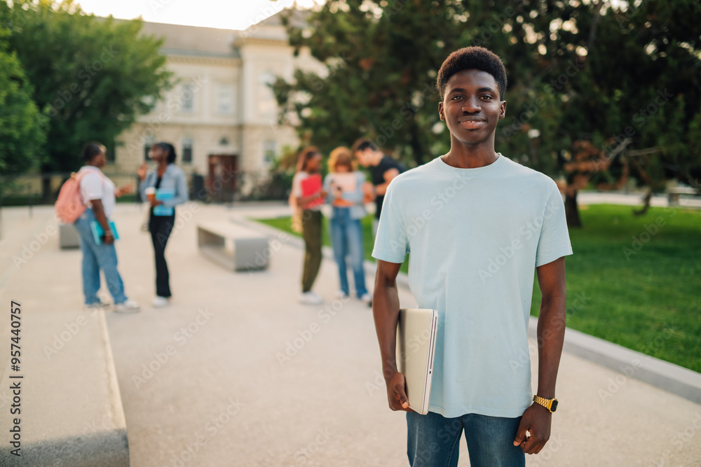Portrait of happy diverse exchange student with laptop looking at camera Portrait of happy diverse exchange student with laptop looking at camera