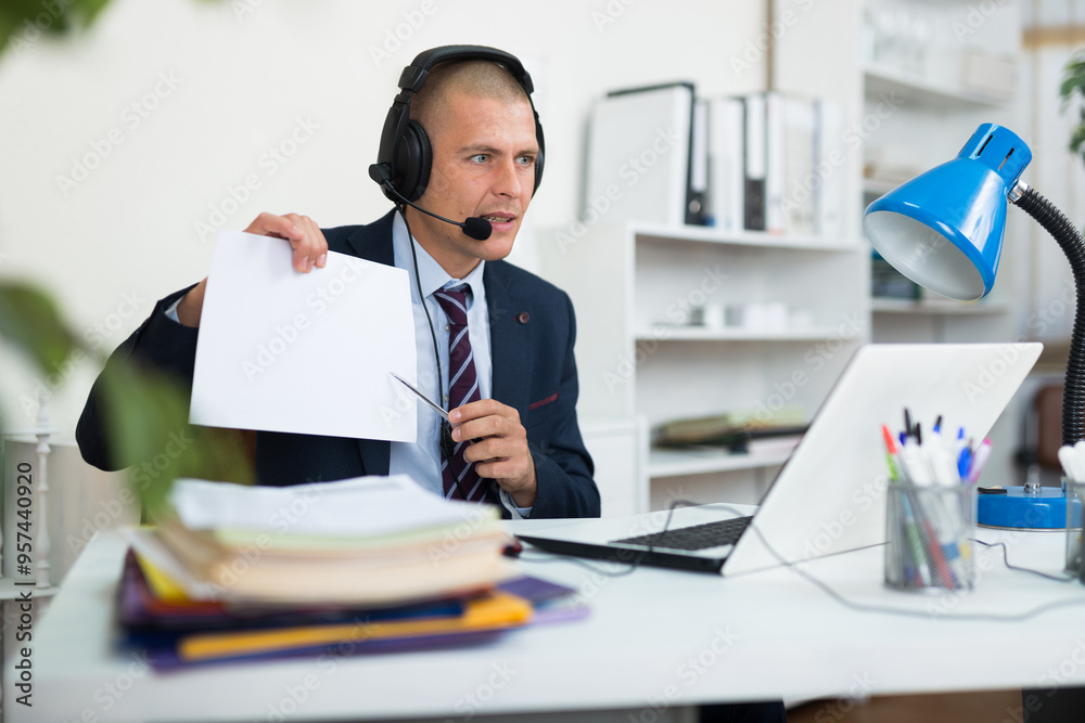 Φωτογραφία Portrait of adult businessman in earphones having online call meeting at workpla