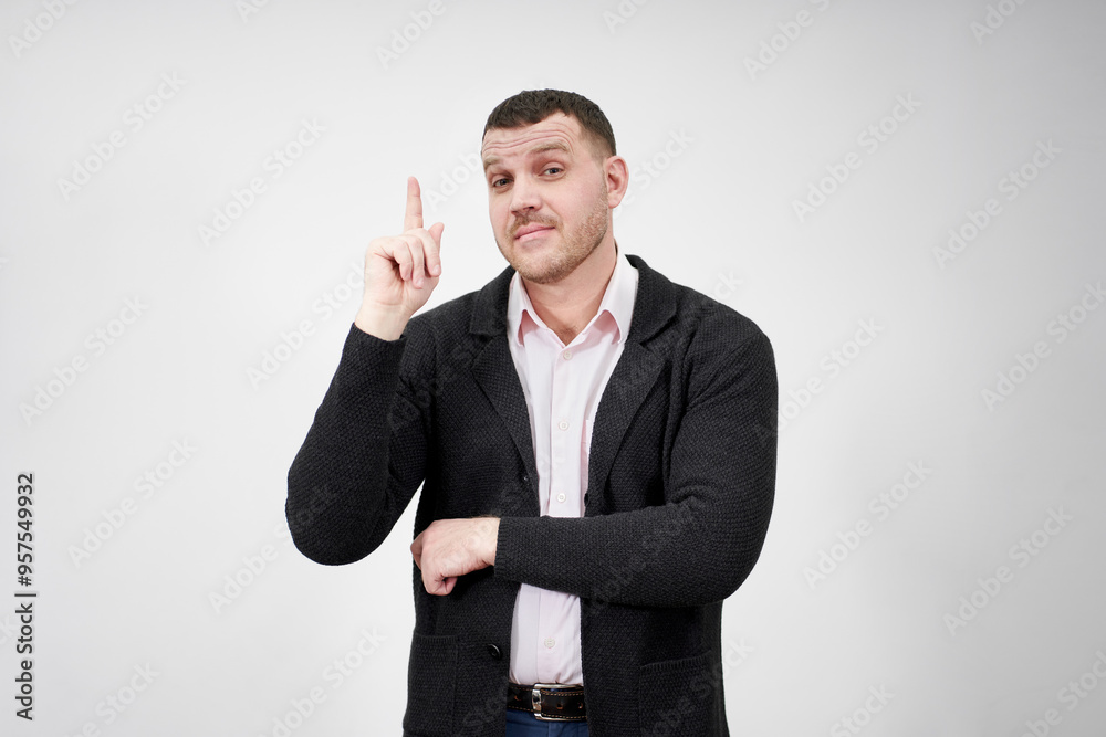 Excited businessman having an idea and pointing finger up at copy space over gray background Excited businessman having an idea and pointing finger up at copy space over gray background