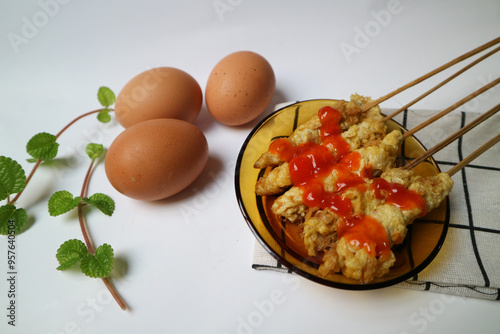 Telur Gulung or Tolled Egg served on a plate with chilli sauce. Rolled Egg Omelette with Skewers. Popular Street Food in Indonesia. photo