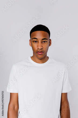 Serious man with neutral expression wearing white t shirt photo