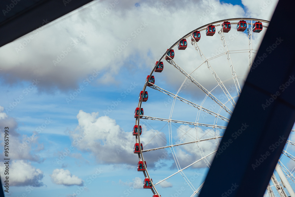 Ferris Wheel with Red Gondolas Against Blue Sky Ferris Wheel with Red Gondolas Against Blue Sky