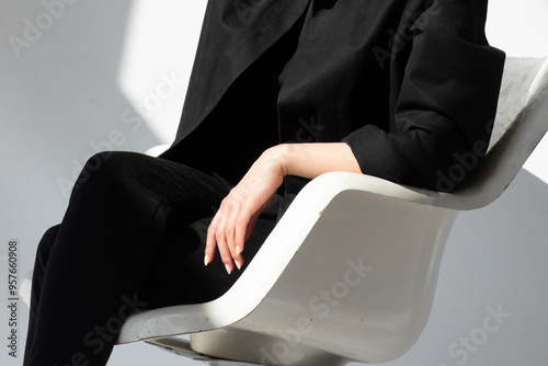 Person sitting in a modern chair with business style clothes