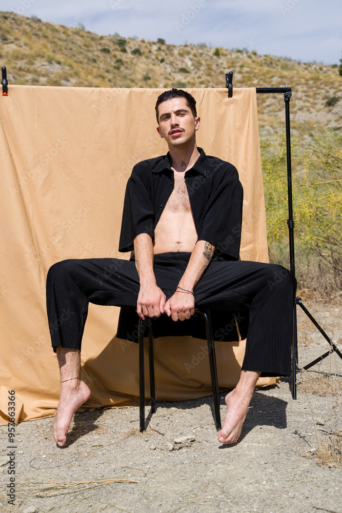 model posing sitting on chair in desert photoshoot model posing sitting on chair in desert photoshoot