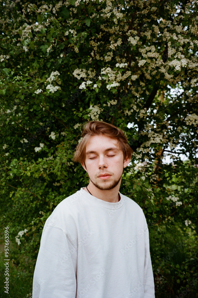 A male portrait with closed eyes in a garden A male portrait with closed eyes in a garden