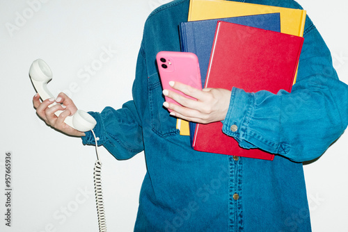 Person holding landline phone, books & smart phones in business office