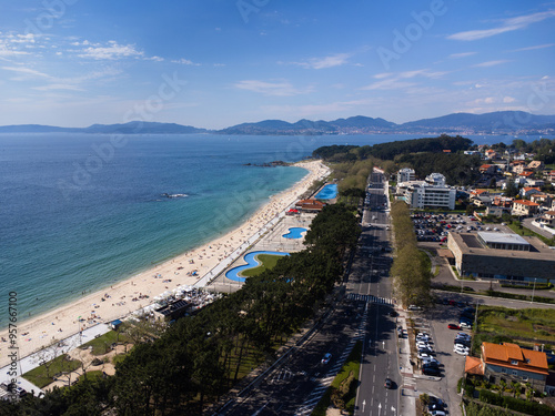 Aerial view of Playa de Samil, the main beach of Vigo in Galicia in northwest Spain. Sunny day, crystal clear blue sea. Houses, streets. Drone