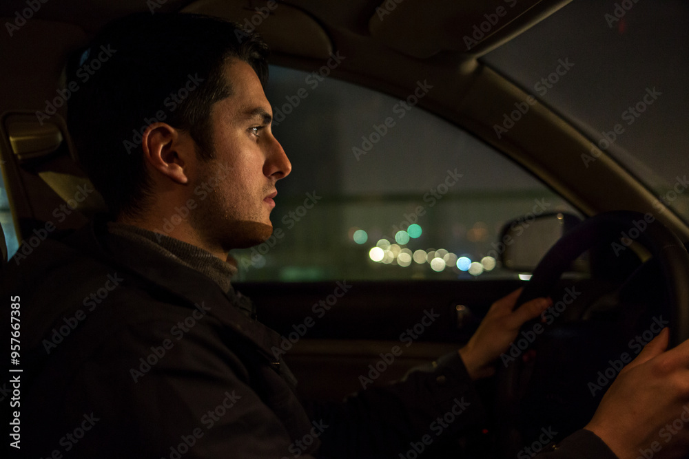 Young man driving car in the night Young man driving car in the night