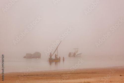 Fishing dhows on a misty morning as the sun rises  photo