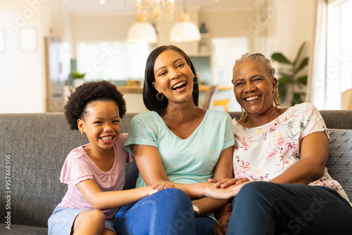 Smiling multigenerational family sitting on couch, enjoying quality time together
