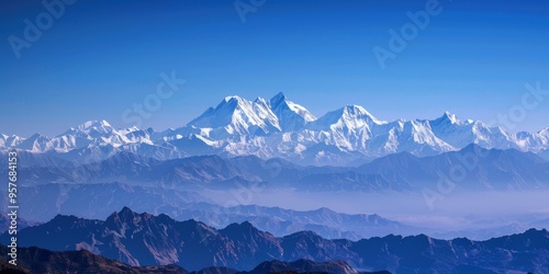 A panoramic view of snow-capped mountains under a clear blue sky, symbolizing grandeur and adventure in the outdoors