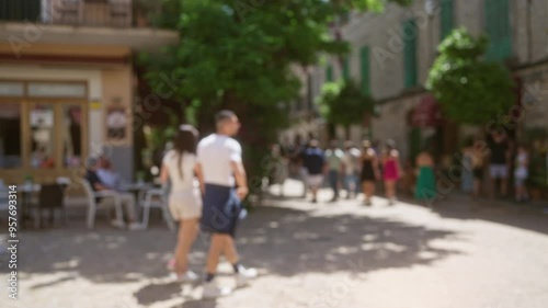 Wallpaper Mural Defocused scene of people walking in a busy sunny outdoor street in mallorca with a blurred man in the foreground Torontodigital.ca