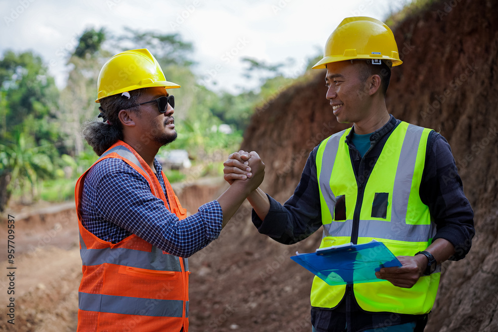 Two construction workers high-five, give thumbs up and shake hands because they have agreed to the work. Two construction workers high-five, give thumbs up and shake hands because they have agreed to the work.